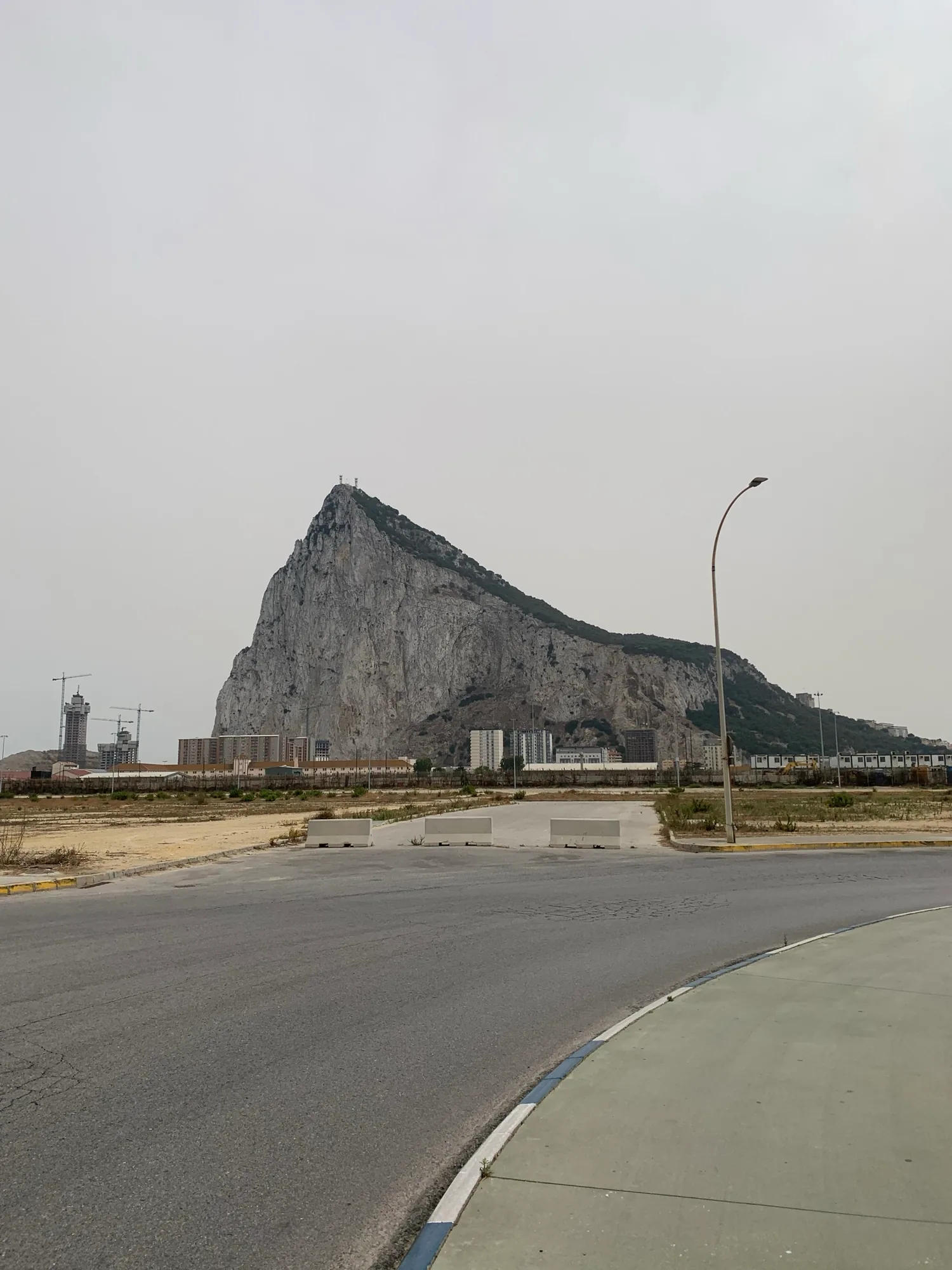 Open parking lot near the Gibraltar frontier with the Rock under a grey sky
