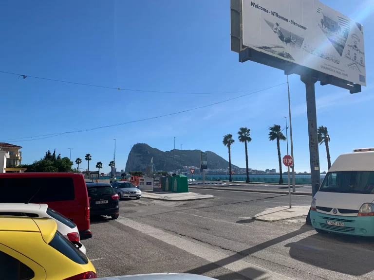 The welcome billboard at the Gibraltar frontier, with the Rock behind it.