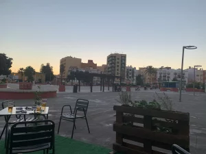 The central plaza of La Linea at sunset, with a terrace in use.
