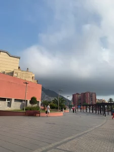 Paved public plaza in La Linea with a pergola walkway and low cloud over the Rock of Gibraltar