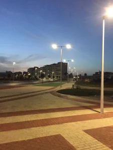 Tiled plaza in La Línea at dusk under street lamps