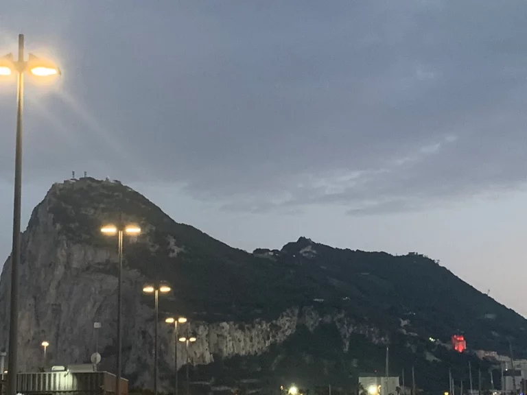 Detail of the Rock of Gibraltar at dusk, its face lit by scattered lamps.