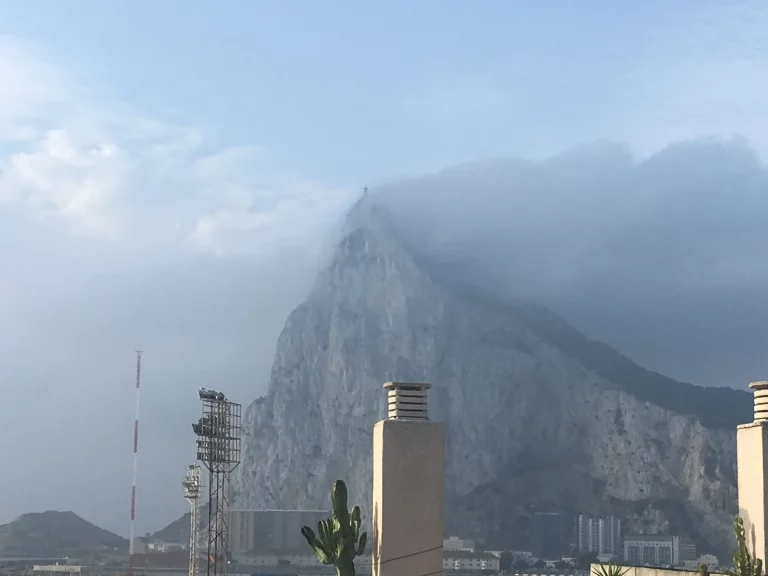 The Rock of Gibraltar under a thick levanter cloud, the cap sitting low over the whole ridge.